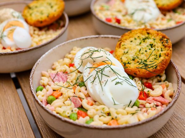 Koude pastasalade met gekookt ei en krokante broodjes